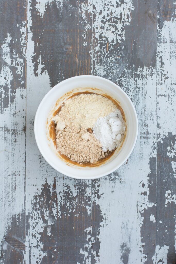 These healthy Peanut Butter Chocolate Protein Cookies are a wholesome, easy-to-make treat that the whole family will love. Adding dry ingredients to mixing bowl.