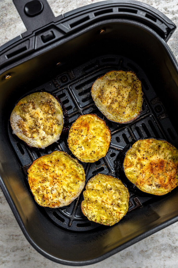 This saucy air fryer eggplant parmesan recipe with fresh mozzarella is the perfect veggie appetizer for dinner parties. Cooked eggplant in the air fryer before adding the sauce and cheese.