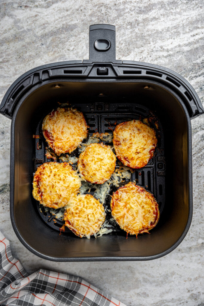 This saucy air fryer eggplant parmesan recipe with fresh mozzarella is the perfect veggie appetizer for dinner parties. Eggplants with tomato sauce and melty cheese in the air fryer basket.