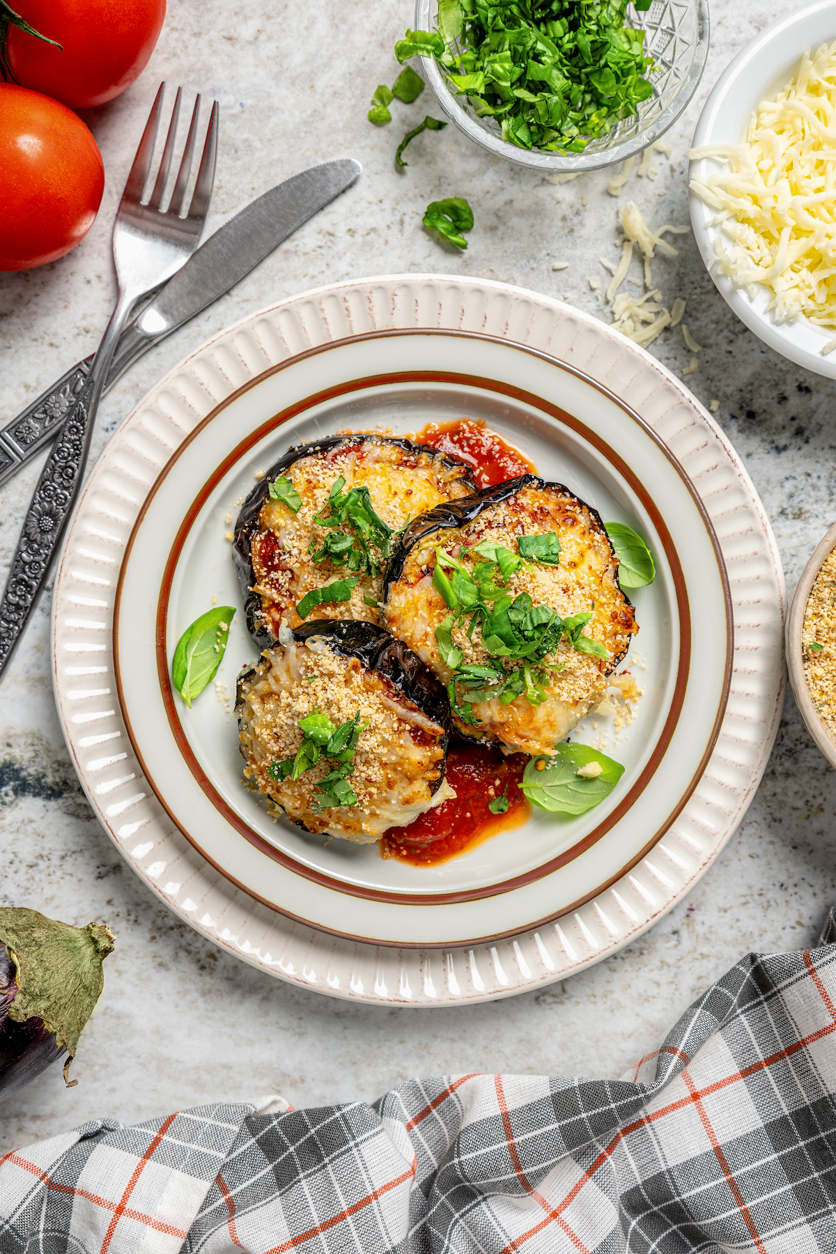 This saucy air fryer eggplant parmesan recipe with fresh mozzarella is the perfect veggie appetizer for dinner parties. Plate of air fryer eggplant parmesan with breadcrumbs and fresh basil on top.