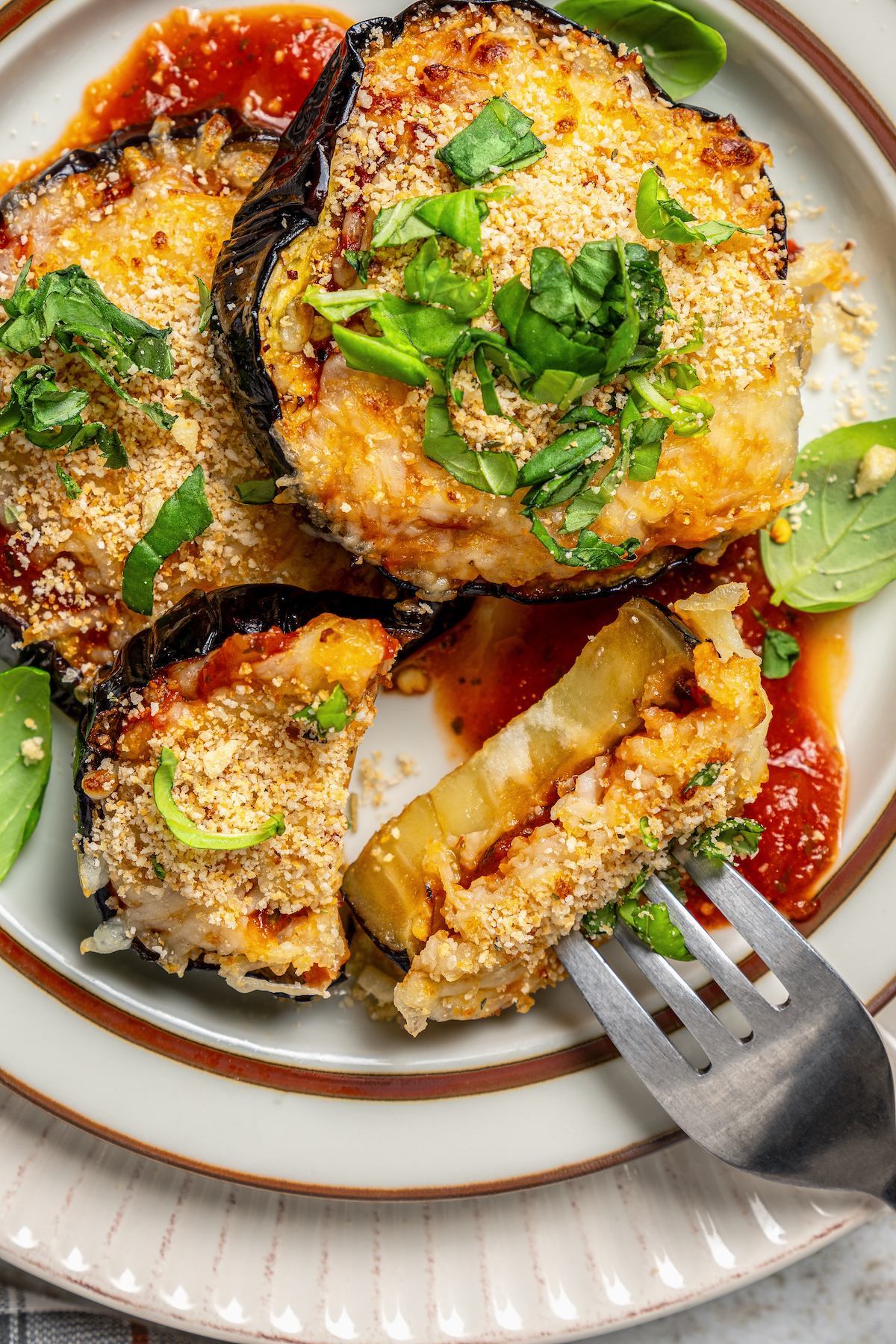 This saucy air fryer eggplant parmesan recipe with fresh mozzarella is the perfect veggie appetizer for dinner parties. Bitten-into eggplant on a fork.