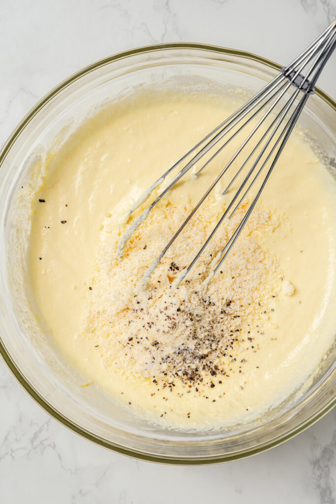This asparagus tartlets recipe with zesty parmesan custard and buttery crust is an easy way to impress guests for brunch. Whisking the creamy filling for the tarts.