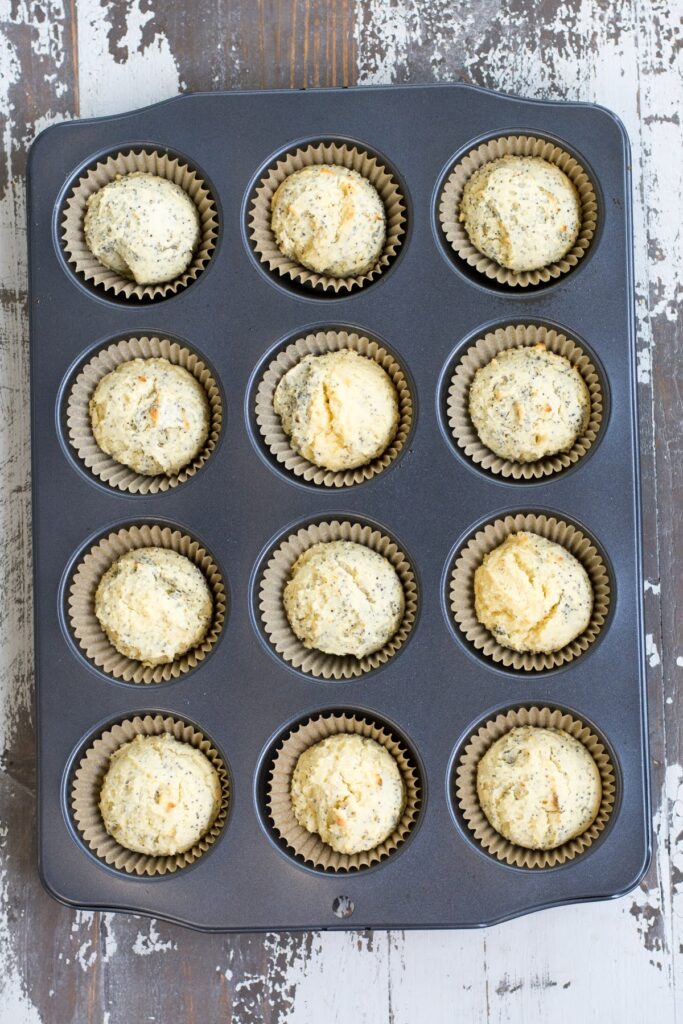 Baked lemon poppyseed muffins in a muffin tin.