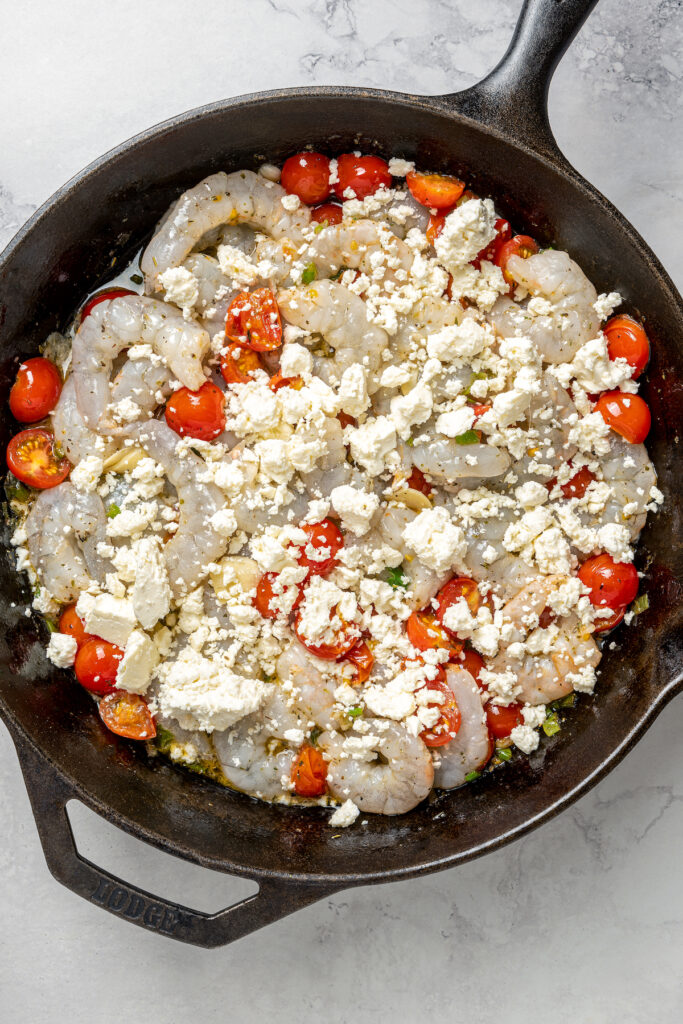 Baked Shrimp with Tomato and Feta is an easy, gluten free, healthy dinner that is made in one skillet and ready in less than 30 minutes. Shrimp and tomatoes topped with feta, ready for baking.