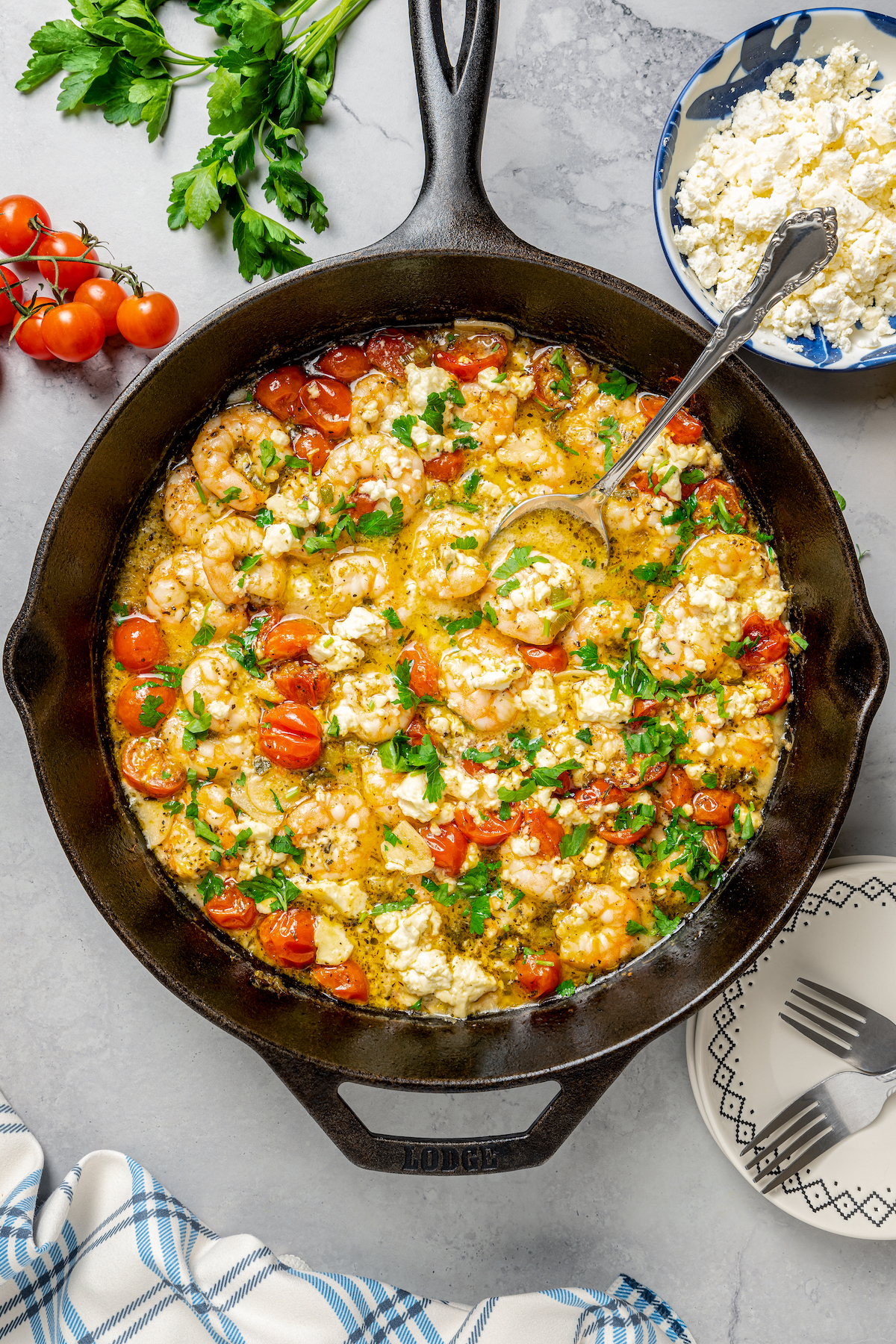 Baked Shrimp with Tomato and Feta is an easy, gluten free, healthy dinner that is made in one skillet and ready in less than 30 minutes. A skillet dish of shrimp and tomatoes.