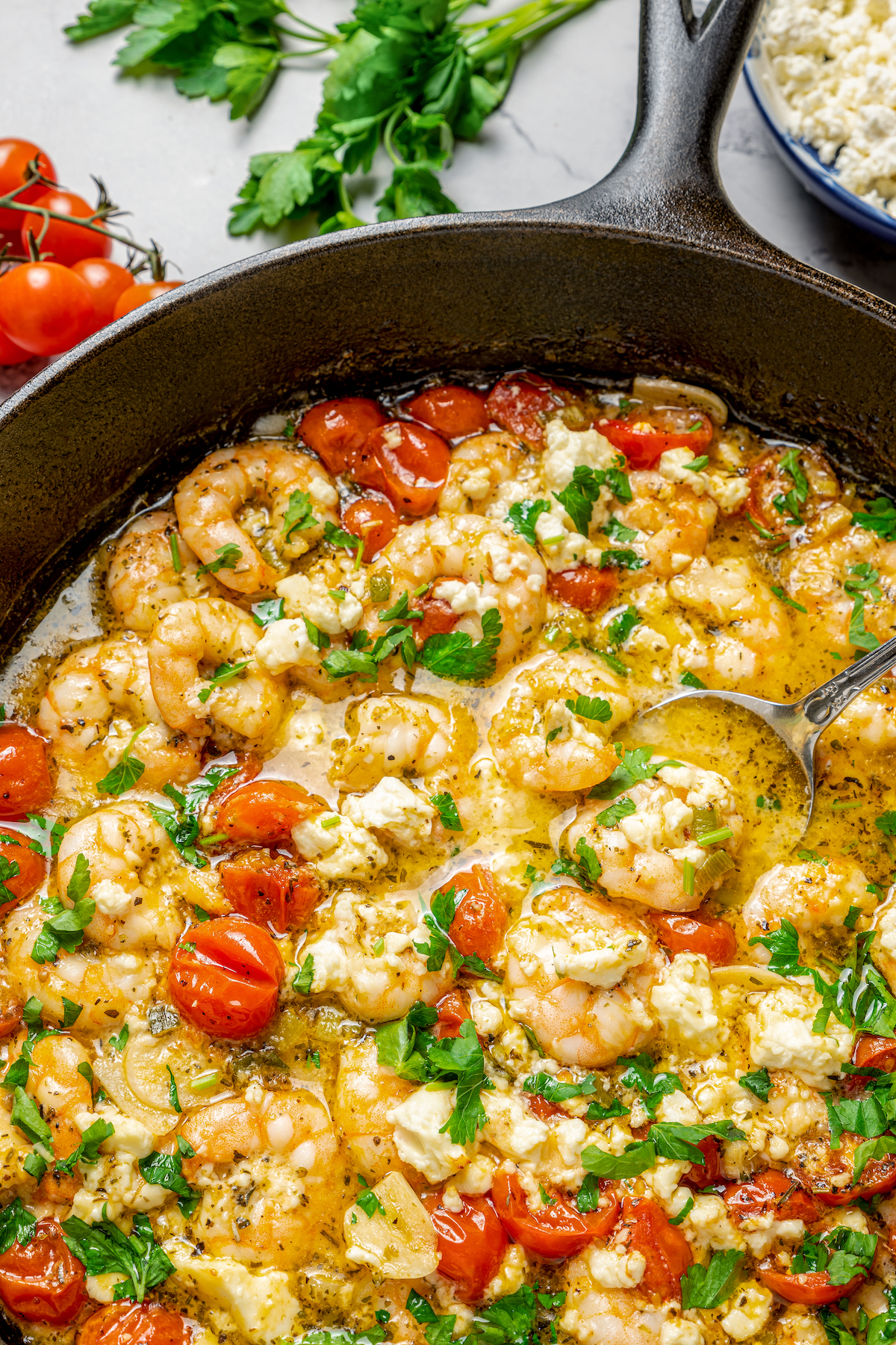 Baked Shrimp with Tomato and Feta is an easy, gluten free, healthy dinner that is made in one skillet and ready in less than 30 minutes. Saucy shrimp in a skillet with herbs and tomatoes.