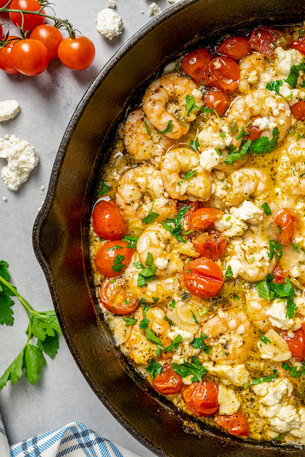 Baked Shrimp with Tomato and Feta is an easy, gluten free, healthy dinner that is made in one skillet and ready in less than 30 minutes. Close-up shot of baked shrimp with feta and tomatoes, to show the texture of the ingredients.