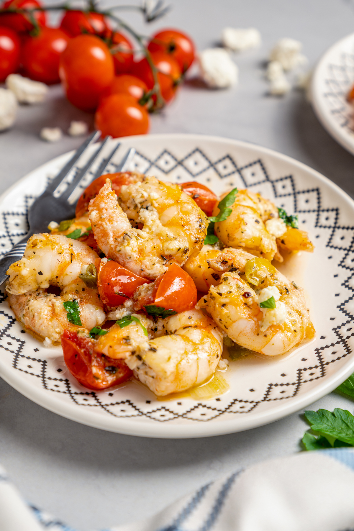 Baked Shrimp with Tomato and Feta is an easy, gluten free, healthy dinner that is made in one skillet and ready in less than 30 minutes. A plate of shrimp with tomatoes and feta.