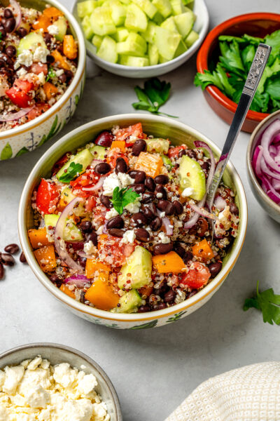 A bowl of healthy Greek salad made with black beans and ancient grains.