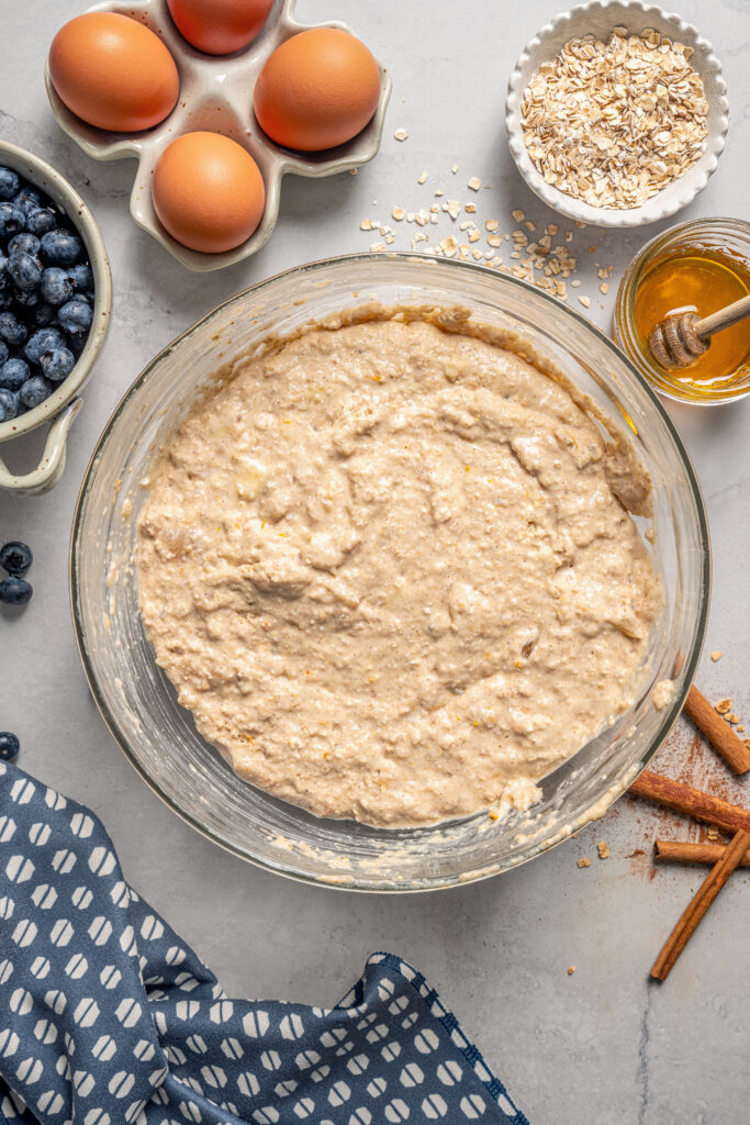 This naturally-sweetened blueberry protein muffins recipe with cinnamon and orange zest is a great on-the-go breakfast. Muffin batter in the bowl.