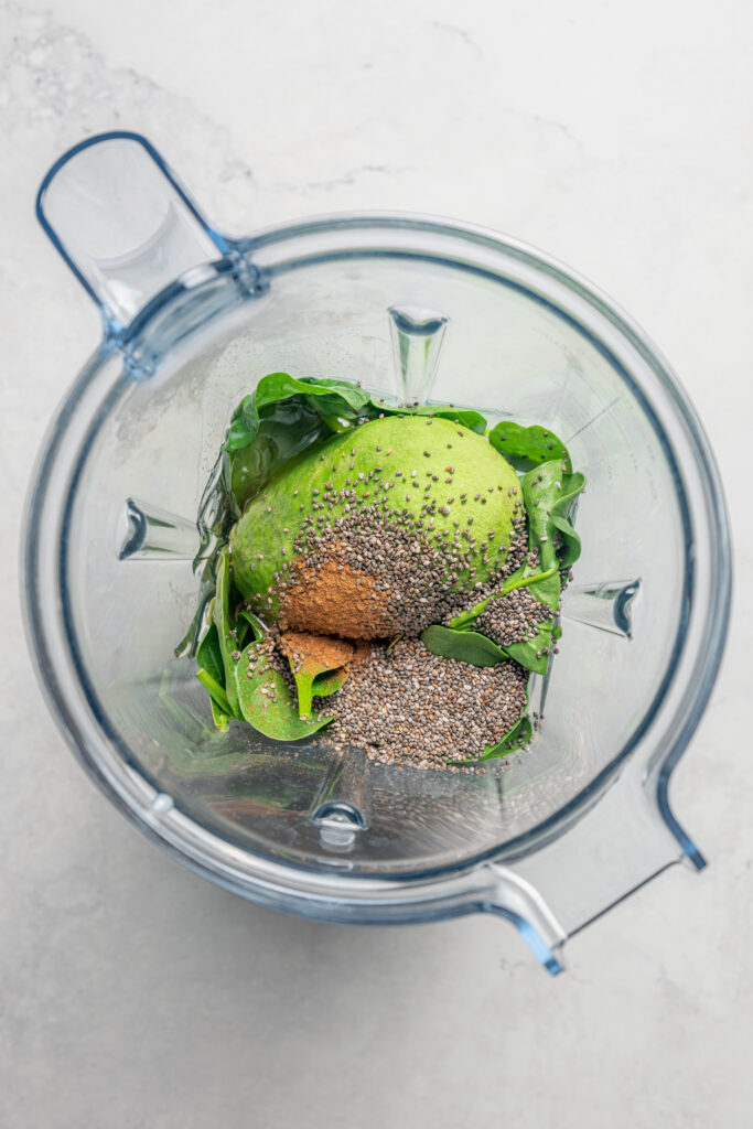 This blueberry-chia superfood smoothie recipe with spinach, avocado, and honey is the perfect way to start your mornings. Adding the ingredients to the blender.