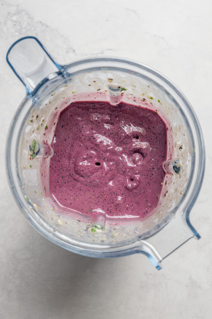This blueberry-chia superfood smoothie recipe with spinach, avocado, and honey is the perfect way to start your mornings. Smoothie mixture in the blender.