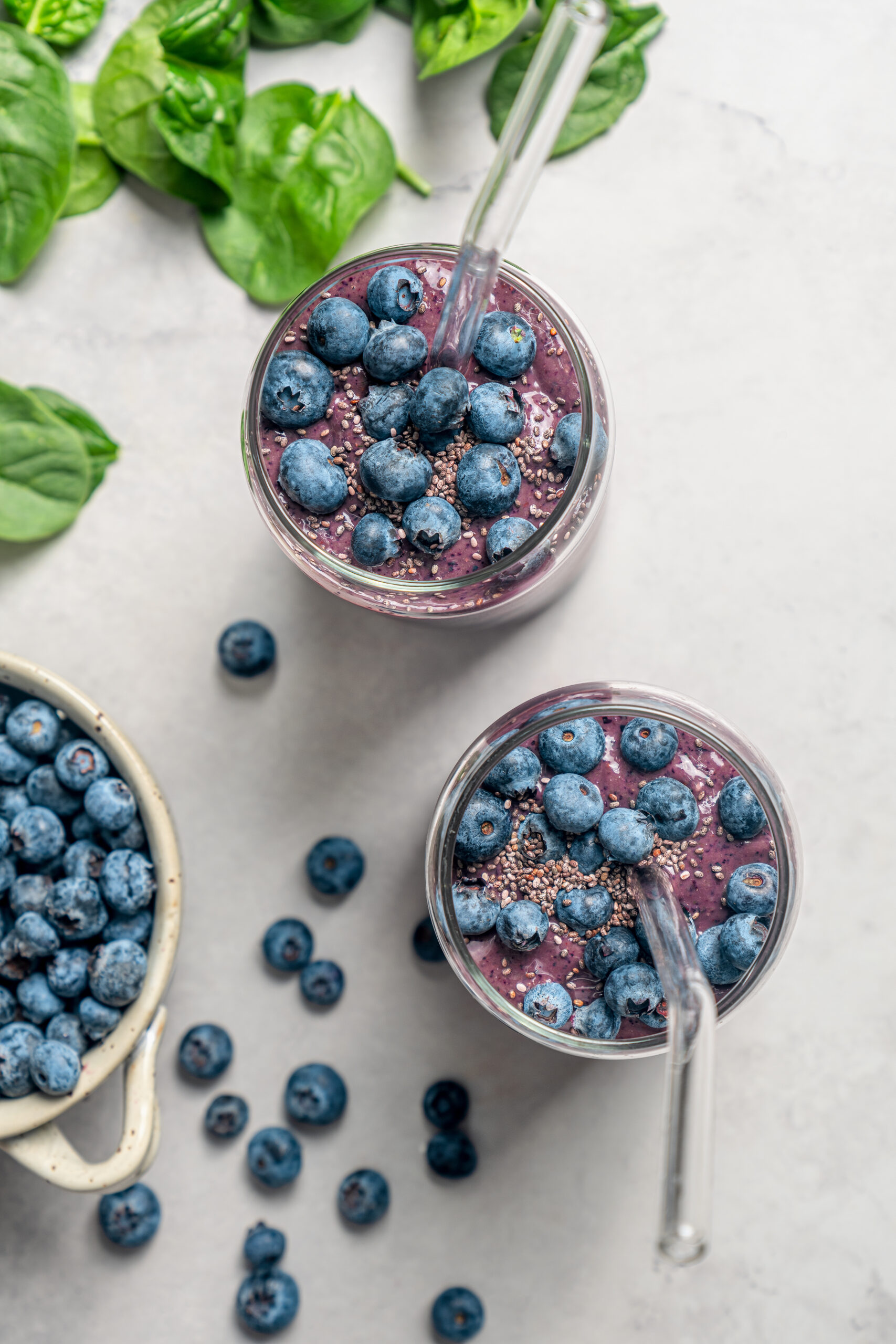 This blueberry-chia superfood smoothie recipe with spinach, avocado, and honey is the perfect way to start your mornings. Two glasses of blueberry superfood smoothies.