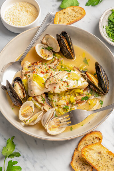 A seafood dinner plate with sliced baguette.