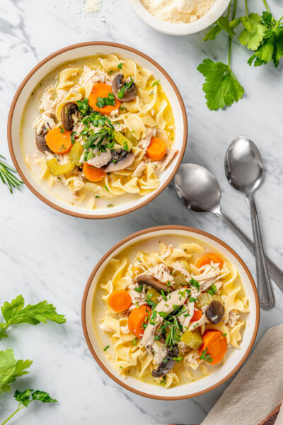 Two bowls of the best chicken noodle soup with cream and noodles.