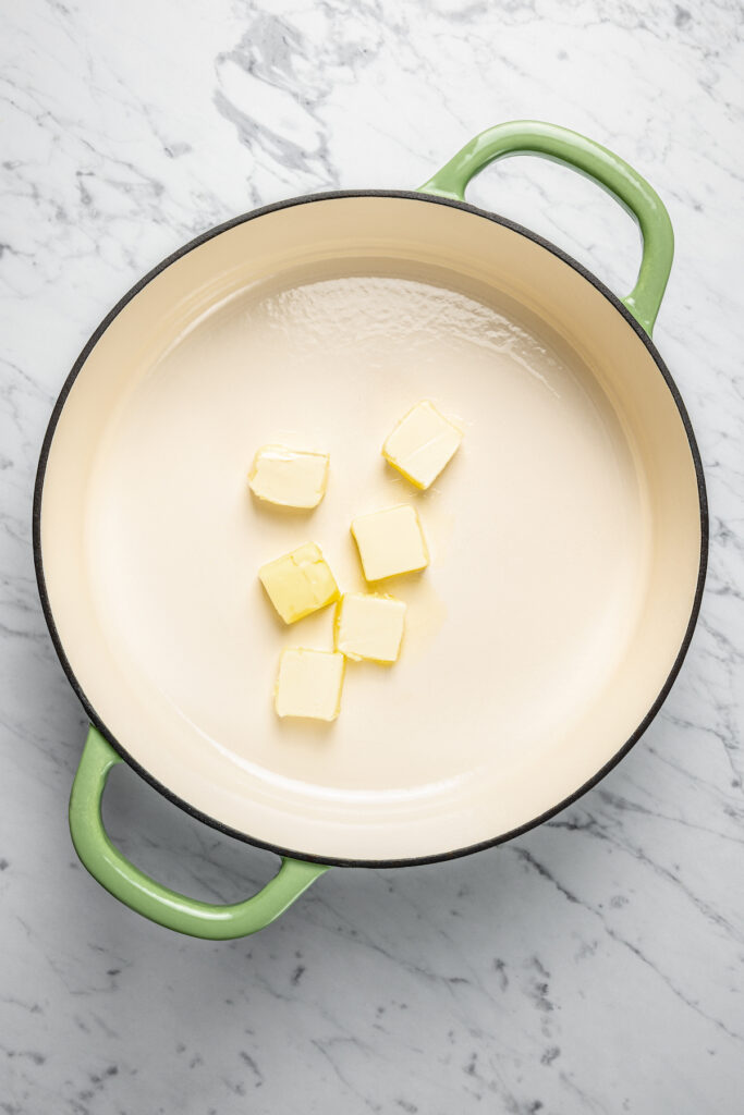 This Creamy Mac and Cheese with Jalapeño and Corn is a little spicy, a little sweet, and very, very cheesy. Irresistible and easy to make! Butter melting in a pot.