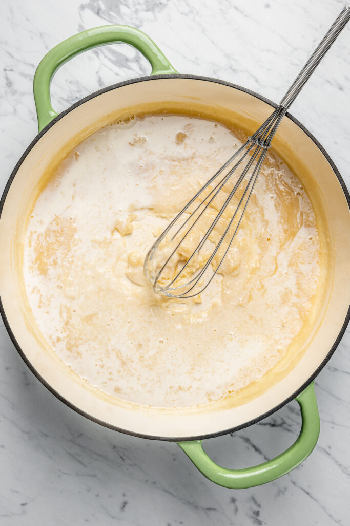 This Creamy Mac and Cheese with Jalapeño and Corn is a little spicy, a little sweet, and very, very cheesy. Irresistible and easy to make! Milk being whisked into a roux.