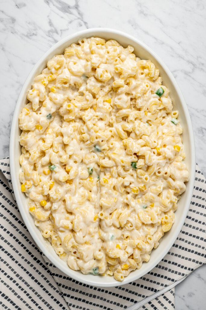 This Creamy Mac and Cheese with Jalapeño and Corn is a little spicy, a little sweet, and very, very cheesy. Irresistible and easy to make! Creamy mac and cheese in a casserole dish.