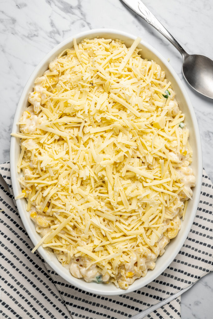 This Creamy Mac and Cheese with Jalapeño and Corn is a little spicy, a little sweet, and very, very cheesy. Irresistible and easy to make! Homemade macaroni topped with additional cheese.