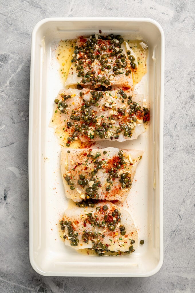 You'll crave the light, fresh flavors of this easy Baked Cod Recipe. Simple prep, perfect texture, and zingy flavor - what could be better? Fish with seasoning mixture poured over.