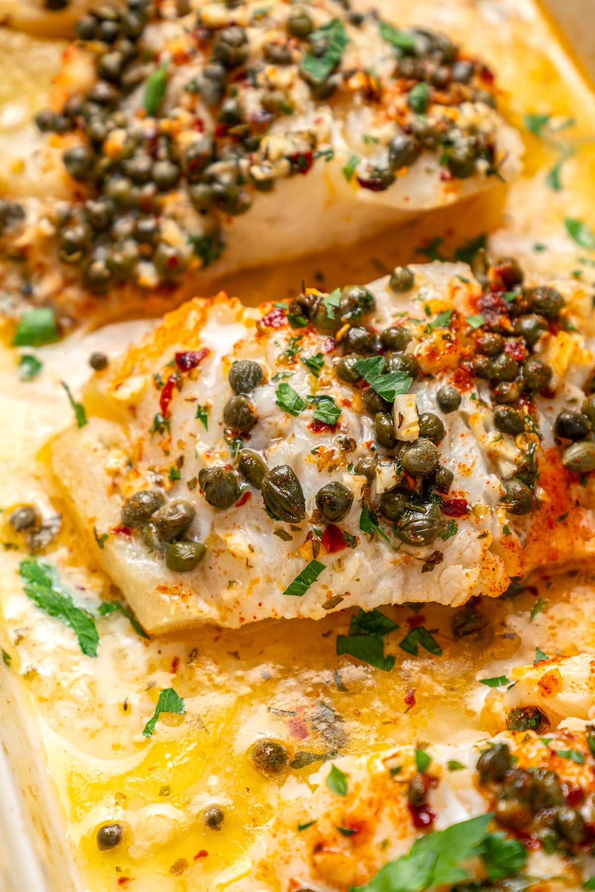 You'll crave the light, fresh flavors of this easy Baked Cod Recipe. Simple prep, perfect texture, and zingy flavor - what could be better? Garlic-herb-caper sauce baked with fish.