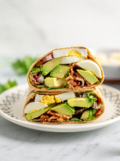 Egg and avocado breakfast wrap on a plate.