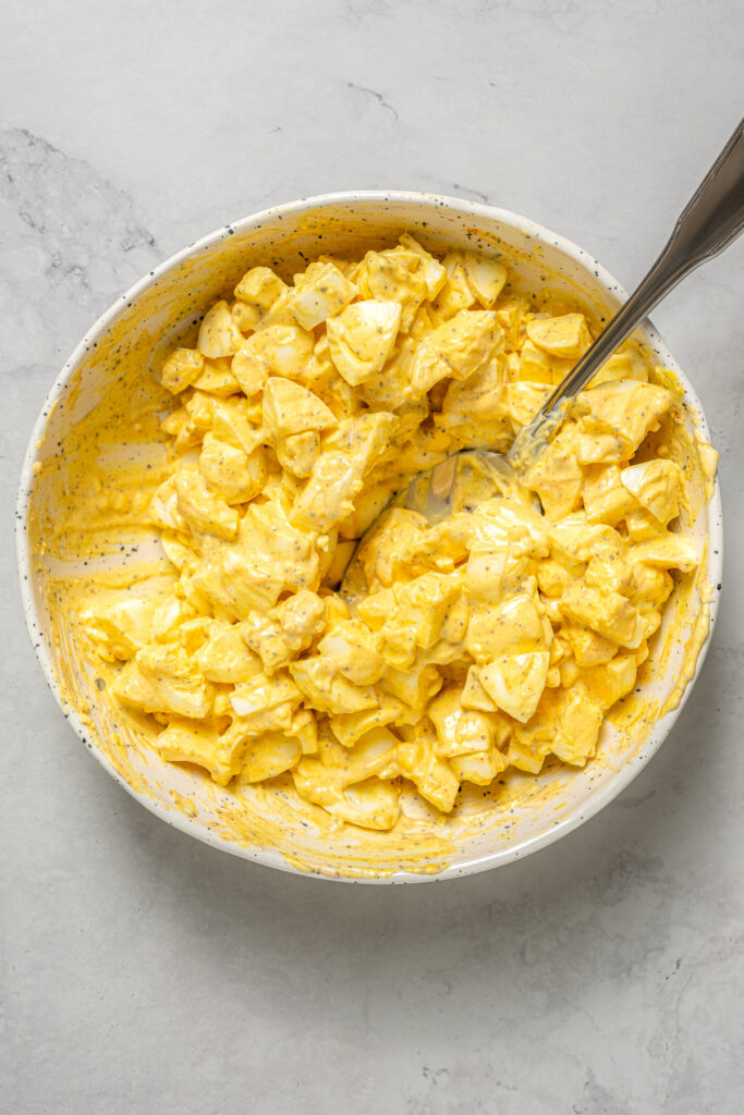 This Healthy Egg Salad is a simple, tasty recipe that’s packed with protein and easy to prepare. A scrumptious lunch or midday snack! Homemade egg salad in a mixing bowl.