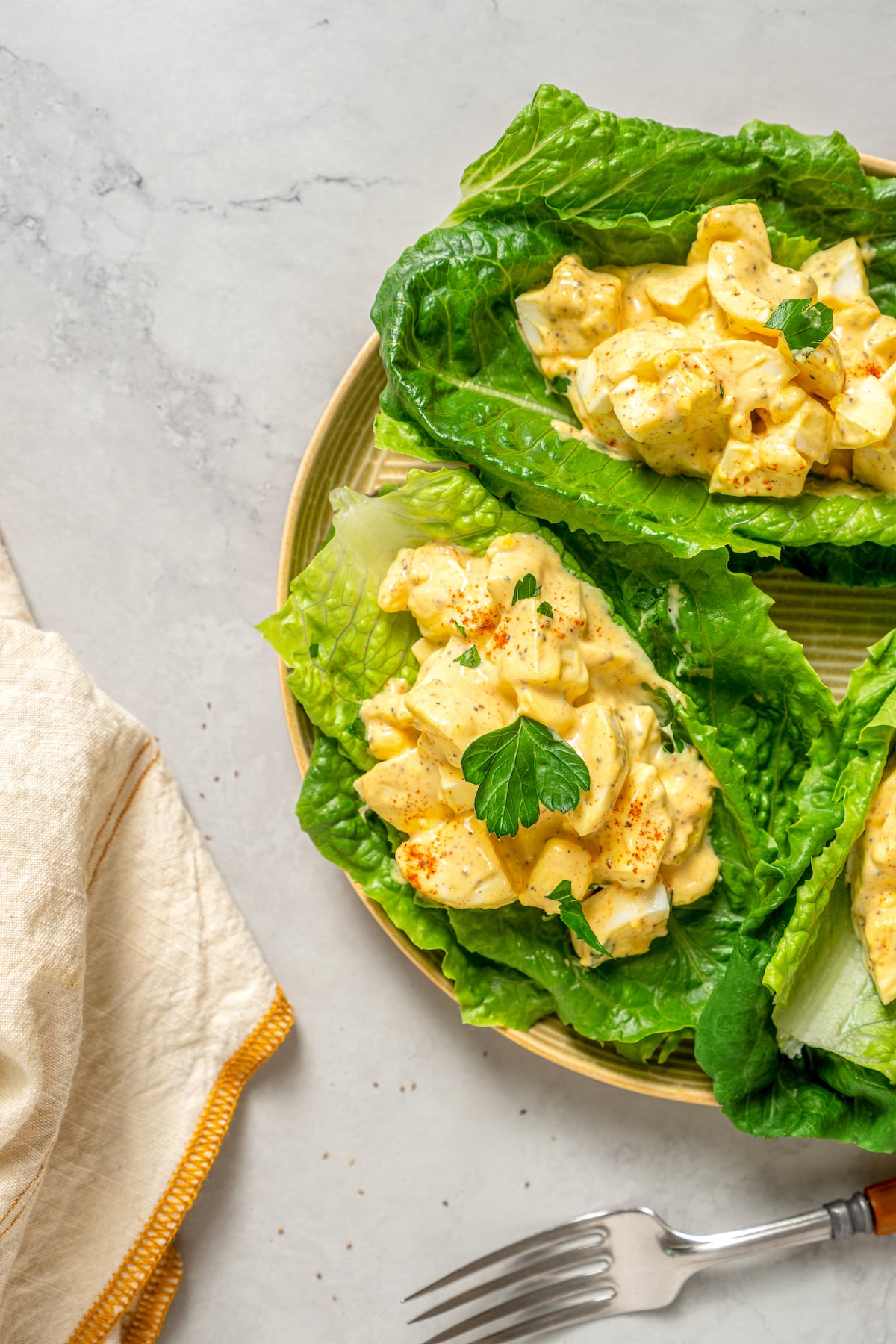 This Healthy Egg Salad is a simple, tasty recipe that’s packed with protein and easy to prepare. A scrumptious lunch or midday snack! A plate of healthy egg salad served on lettuce.