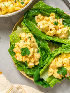 Portions of healthy egg salad spooned onto romaine leaves.