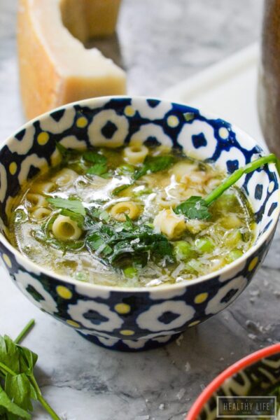 Bowl of garden minestrone with parmesan cheese in background