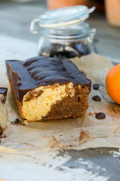 Chocolate orange marble cake, with one slice removed to show the texture of the interior.