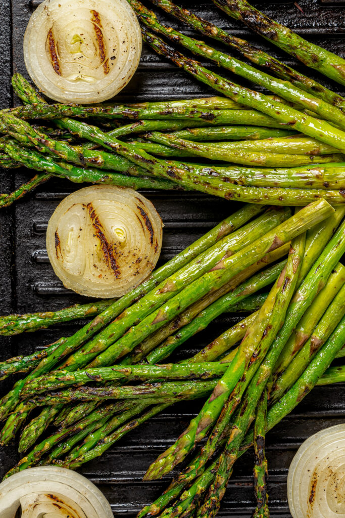 Onions and asparagus on a grill.