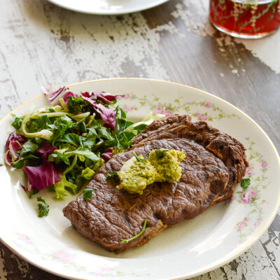 Grilled bison steak with a side salad.