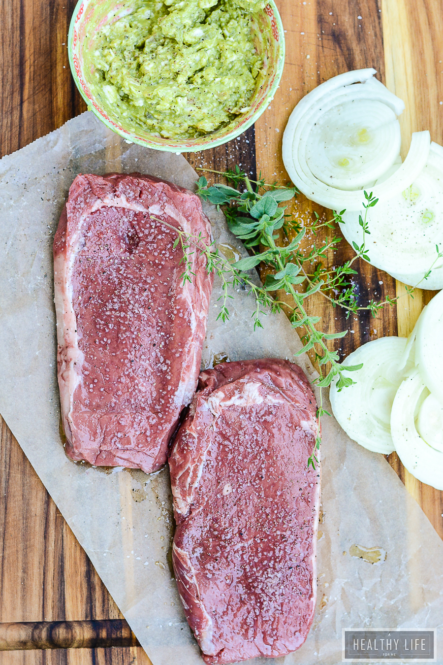 This juicy, 10-minute bison steak recipe with avocado butter will keep you busy at all your cookouts this year. Raw steaks and avocado butter in a bowl.