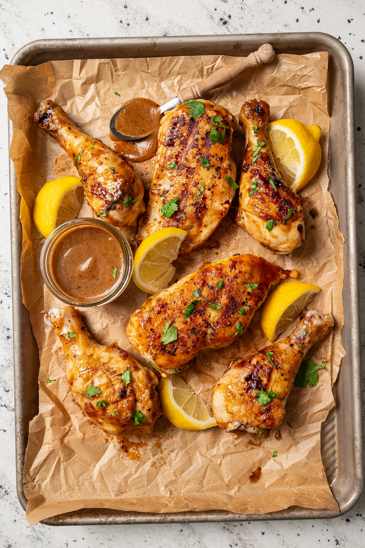 This perfectly juicy grilled chicken recipe with homemade sweet-and-savory sauce is an easy Asian-style dinner. Juicy grilled chicken with lemon wedges and Asian BBQ sauce on the side.