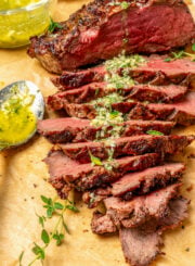Sliced beef roast with garlicky Sicilian herb sauce on top.