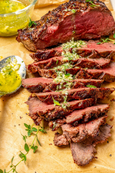 Sliced beef roast with garlicky Sicilian herb sauce on top.