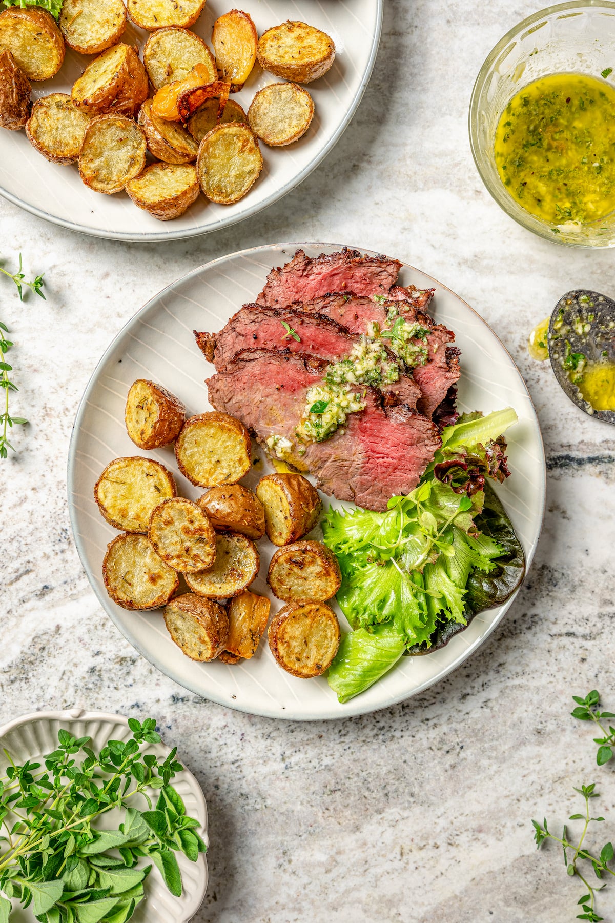 This juicy grilled tri tip recipe with homemade Sicilian herb sauce is an easy dinner for your next summer cookout. Sliced tri tip with herb sauce, roasted baby potatoes, and a fresh salad on the side.