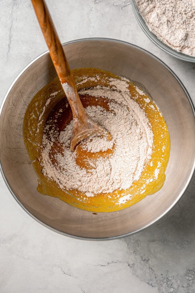 This spiced pumpkin bread recipe with whole-wheat flour, creamy yogurt, and brown sugar is the perfect fall-flavored breakfast. Combining the dry ingredients and wet mixture in a bowl.