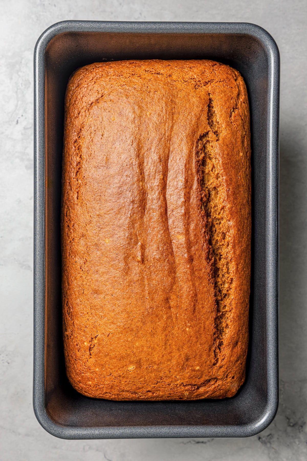 This spiced pumpkin bread recipe with whole-wheat flour, creamy yogurt, and brown sugar is the perfect fall-flavored breakfast. Baked pumpkin bread in the loaf pan.