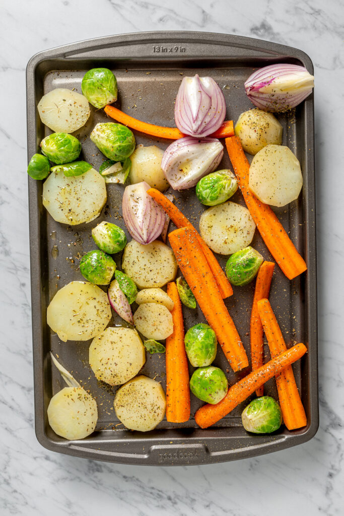 This Pan Seared Steak Recipe with Roasted Vegetables is hearty, filling, and easy to make. A crazy-good marinade brings it all together! Vegetables roasting on a baking sheet.
