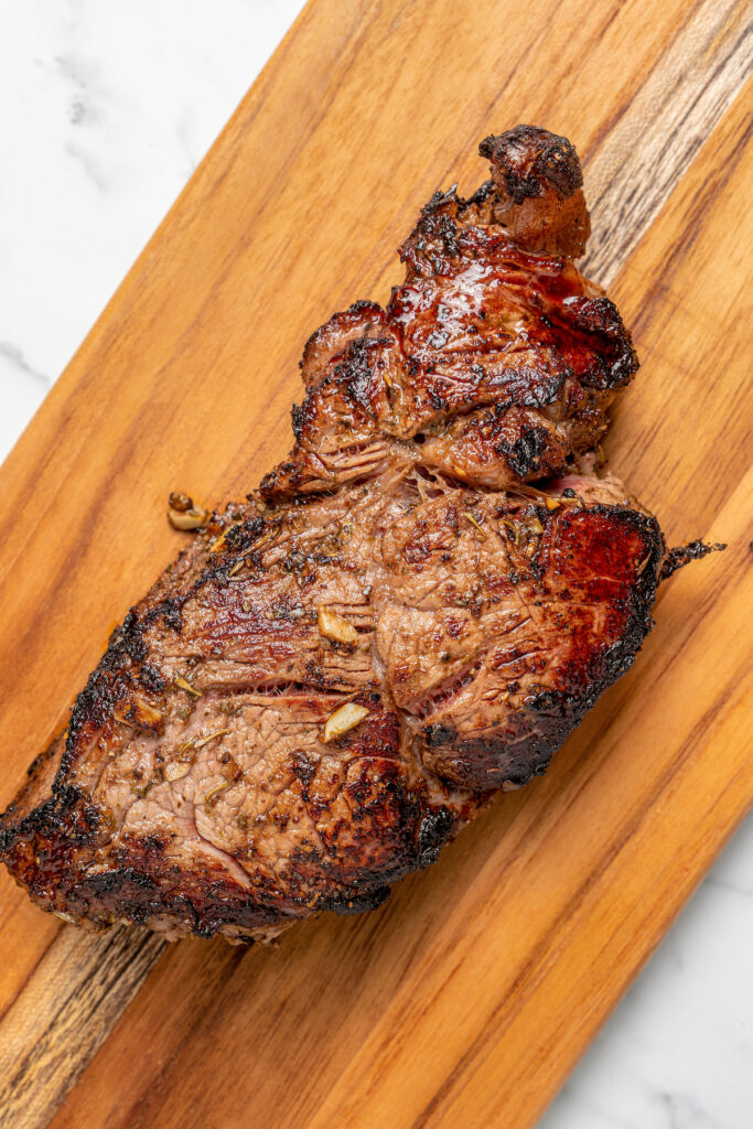 This Pan Seared Steak Recipe with Roasted Vegetables is hearty, filling, and easy to make. A crazy-good marinade brings it all together! A steak on a cutting board.