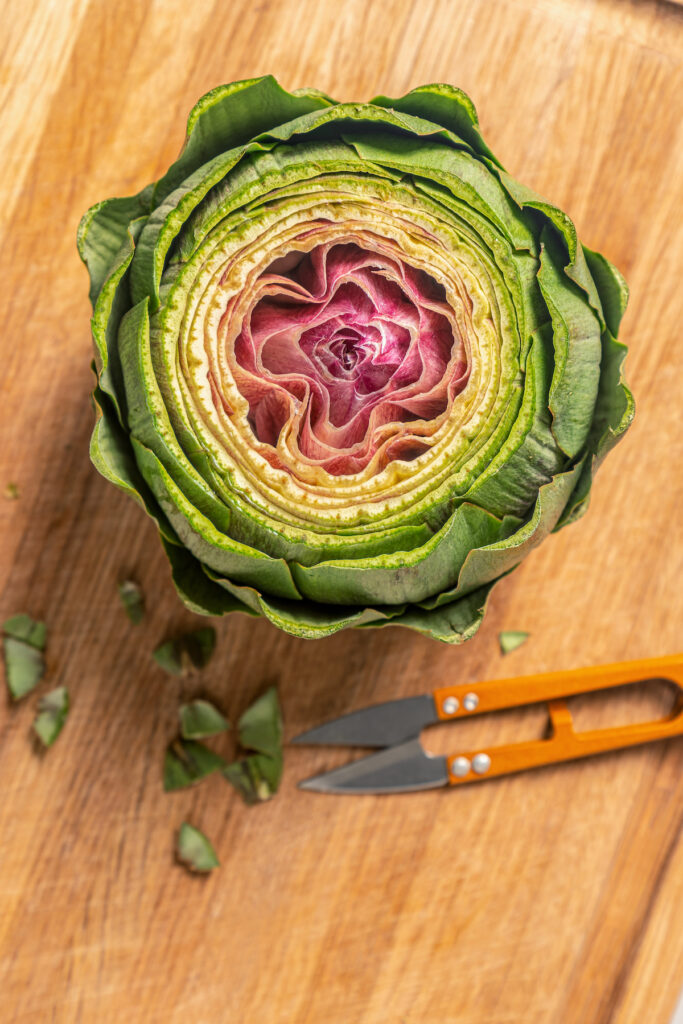 This tender Instant Pot artichokes recipe with hints of tangy lemon, garlic, and fresh herbs will be your go-to holiday side dish. Using kitchen shears to cut the tips of the leaves.