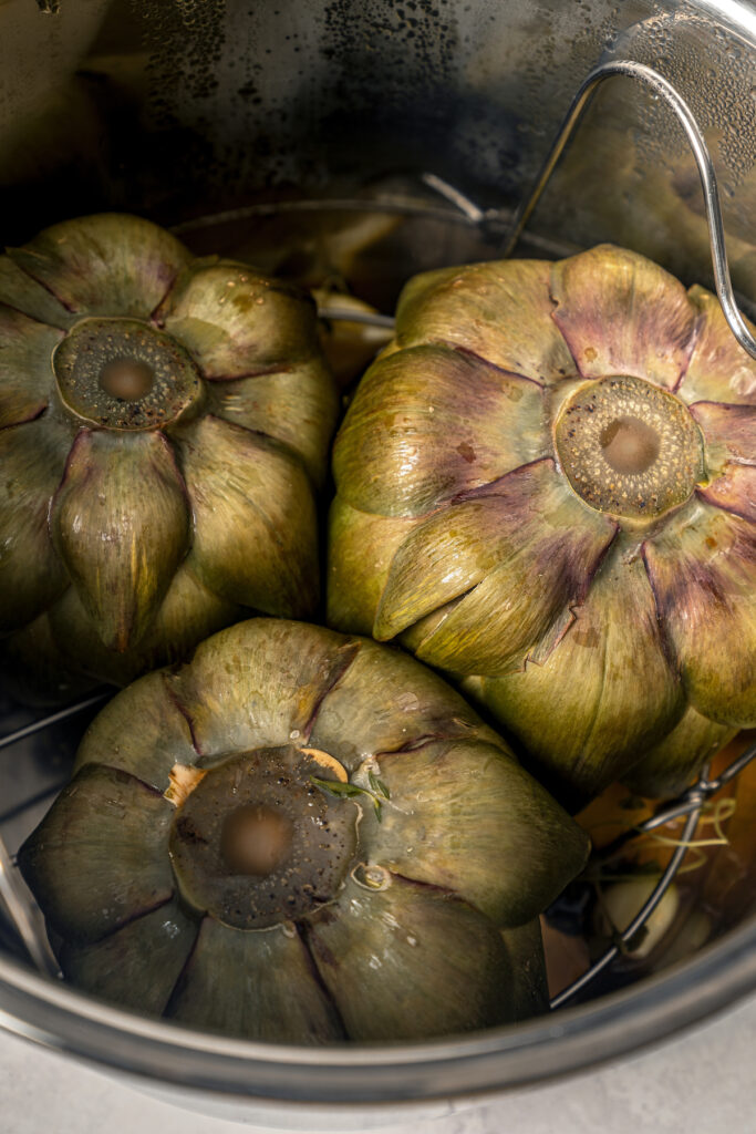 This tender Instant Pot artichokes recipe with hints of tangy lemon, garlic, and fresh herbs will be your go-to holiday side dish. Pressured cooked artichokes.