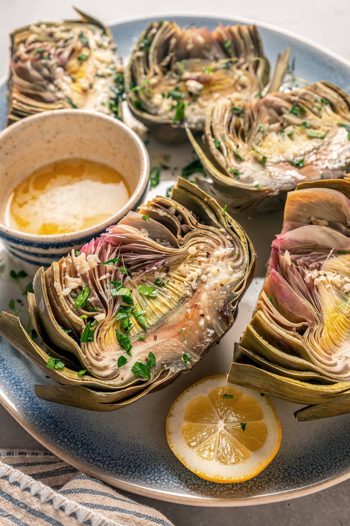 This tender Instant Pot artichokes recipe with hints of tangy lemon, garlic, and fresh herbs will be your go-to holiday side dish. Pressure cooked artichokes with a dipping sauce on the side.
