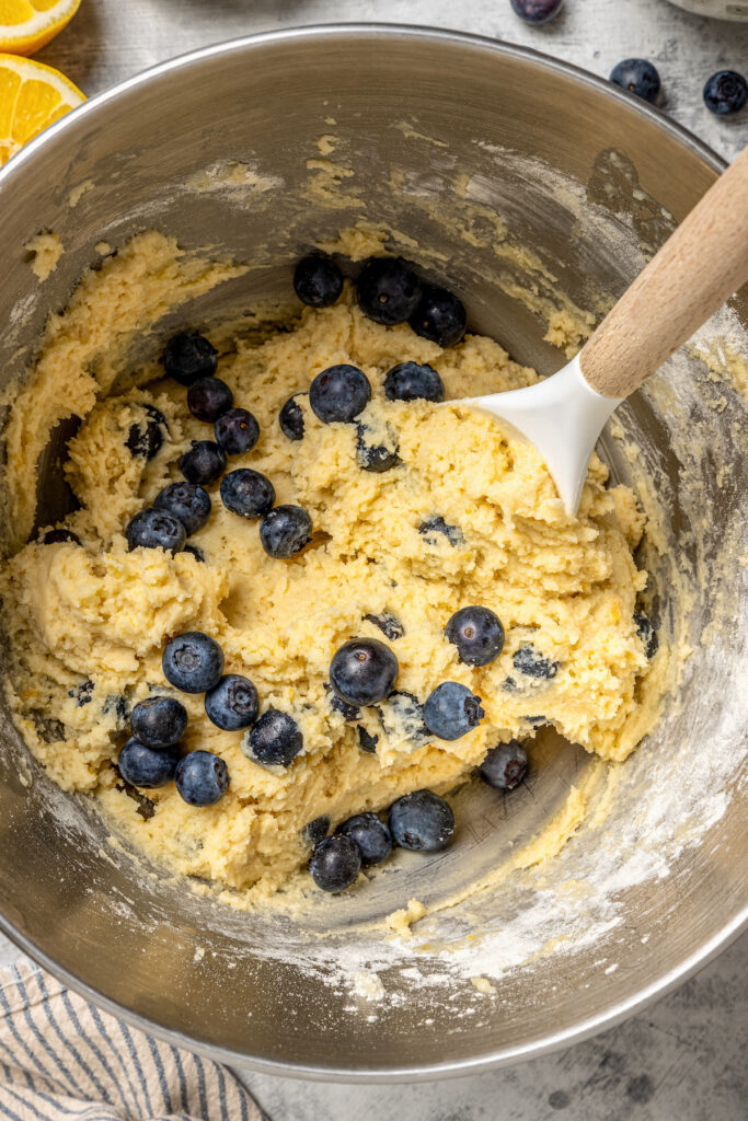 These lemon-blueberry ricotta muffins with crunchy almonds are an easy 20-minute baked treat. They're so light and fluffy you'd never guess they're gluten-free! Add shredded coconut for extra fruity vibes. Gently folding in the blueberries.