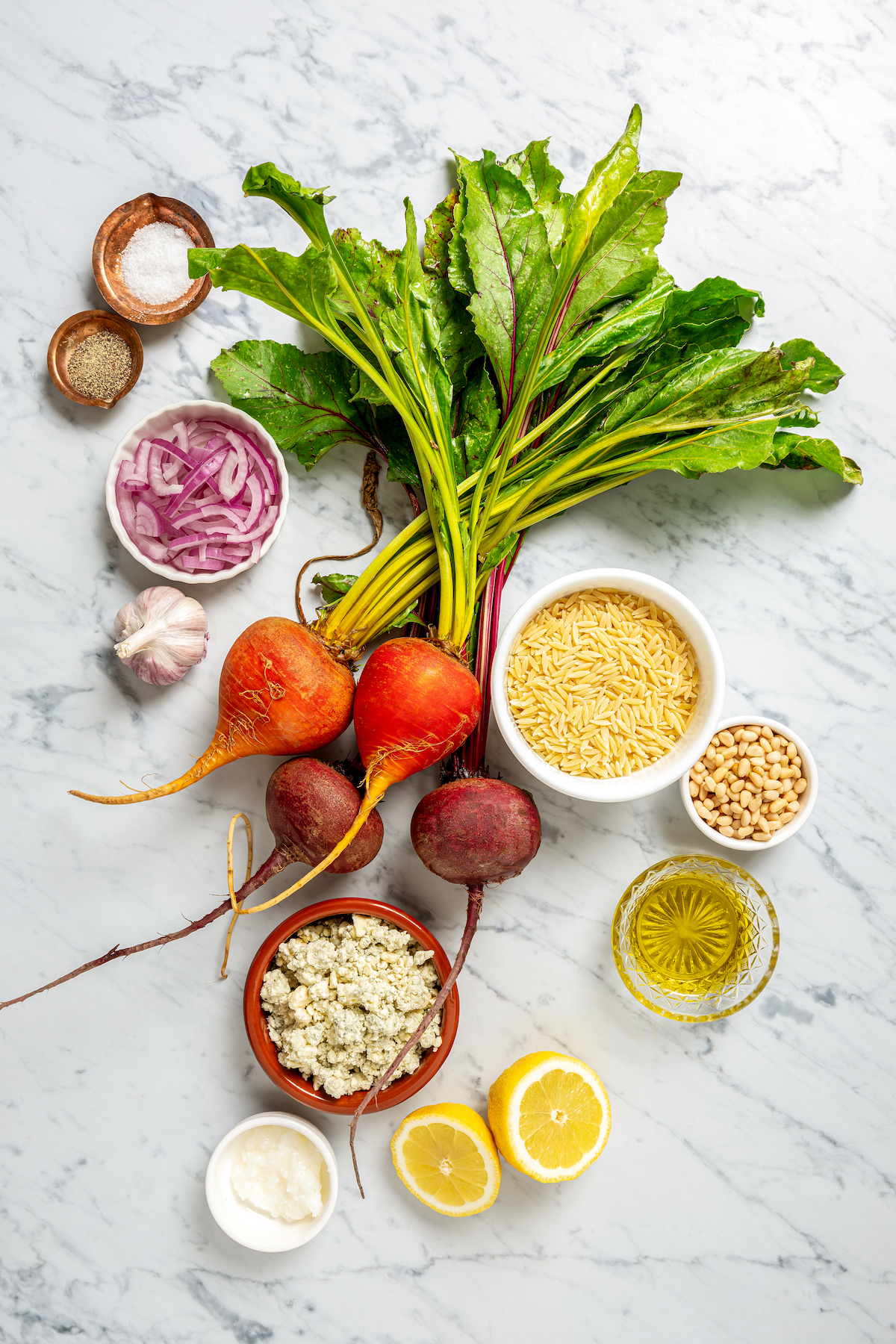 This vibrant Orzo Salad is made with beets, pasta, toasted pine nuts, and blue cheese - a wholesome side dish that everyone will love. Ingredients for orzo salad with beets arranged on a work surface.