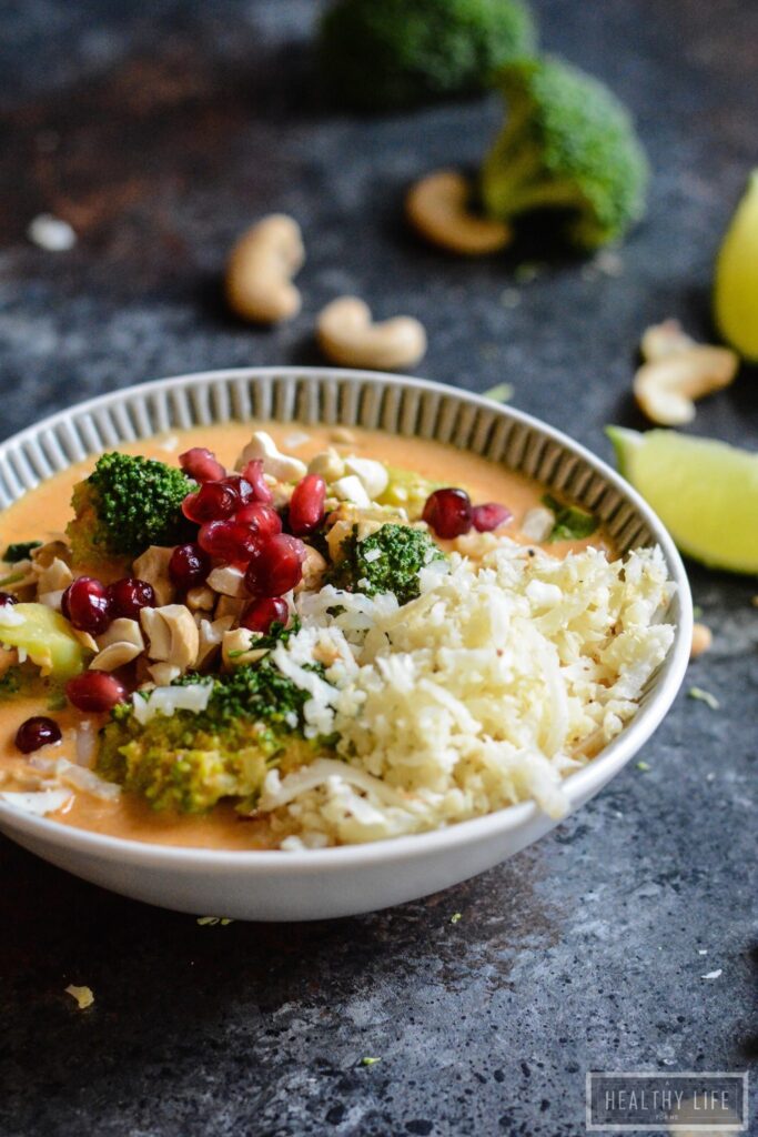 Paleo Thai Curry Chicken is a healthy, feel-good dinner recipe. Addictively delicious Thai-inspired flavors, ready in less than 30 minutes! A bowl of curry chicken with cauliflower rice and pomegranate arils.