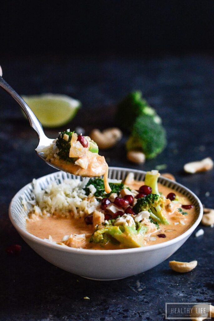 Paleo Thai Curry Chicken is a healthy, feel-good dinner recipe. Addictively delicious Thai-inspired flavors, ready in less than 30 minutes! Spooning red curry out of a bowl.