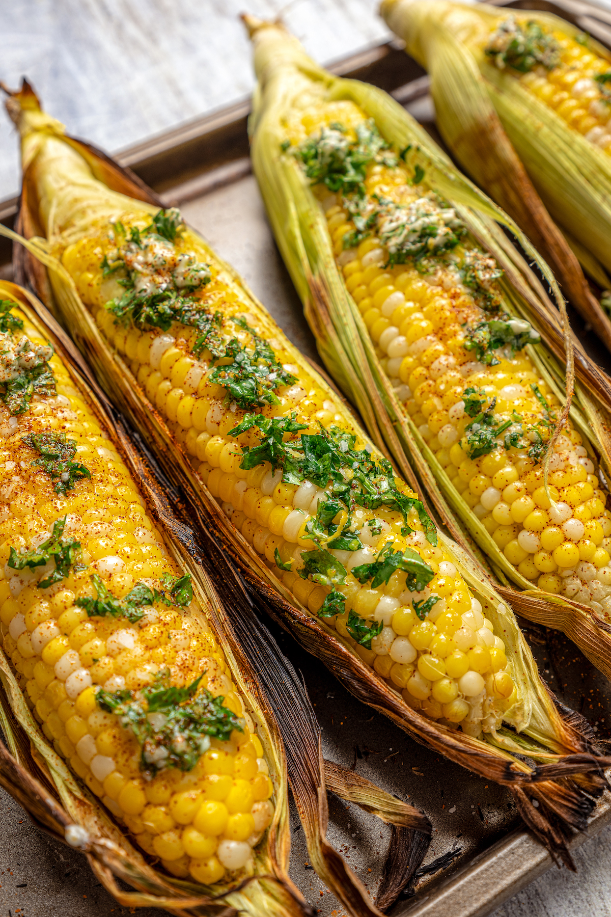 Sweet, fresh corn is a must-have in the summer, and this easy Grilled Corn is loaded with a unique nutty taste that you're sure to love! Ears of grilled corn with cilantro-lemon butter on top.